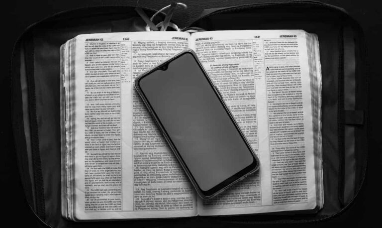 black and white photo of seo dictionary with cell phone placed on top.